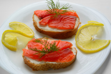 Sandwich with soft cheese and salmon on white background