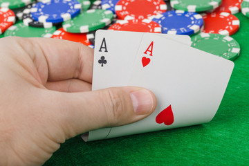 Hand with playing cards in casino