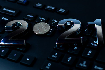 Wall Mural - black keyboard close-up. on it are laid out numbers of metal 2021 in the center of the coin 0.25 dallar.