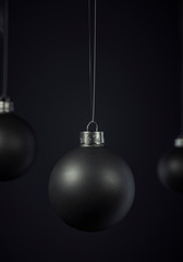 Matte black Christmas ball hanging centered on a black background