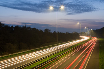 Traffic on a highway with streetlights during dusk. Long exposure.