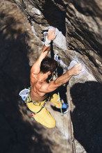 Man Rock Climbing On Tough Sport Route, Rock Climber Makes A Hard Move.