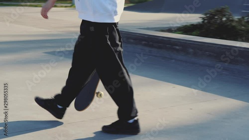 Fotografía Closeup of skateboarder's legs in concrete skatepark on autumn day