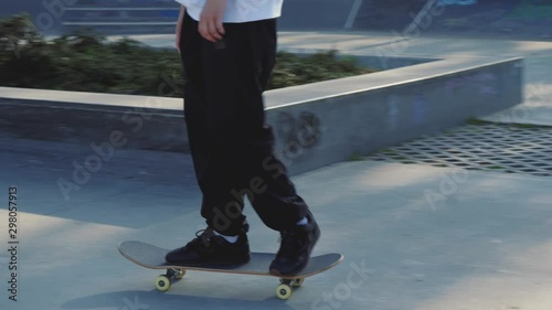Fotomural Closeup of skateboarder's legs in concrete skatepark on autumn day