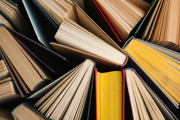 Stack of hardcover books as background, top view