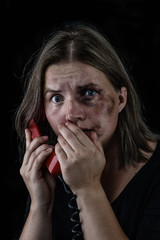 Wall Mural - Woman victim of domestic violence and abuse asks for help by phone. Empty space for text. Isolated on dark background