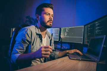 Poster - Profile photo of it specialist guy working late at night sitting office chair looking monitors website debugging expert have problems service error dark office indoors