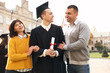 © New Africa - Happy student with parents after graduation ceremony outdoors