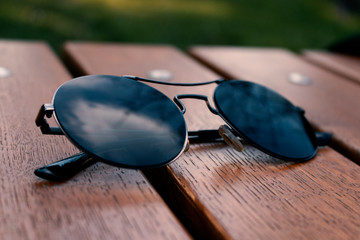 sun glasses on a wooden background,