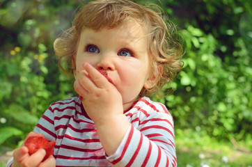 Sticker - beautiful little girl enjoying strawberries in the garden