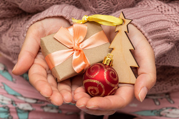 Wall Mural - hands in a knitted sweater holding gift present box. Christmas holidays preparation concept.