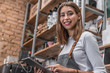 © InsideCreativeHouse - Portrait of a smiling coffee shop owner standing inside her shop and using digital tablet