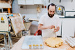 © Alberto Menendez/ADDICTIVE STOCK - bearded man in white t-shirt putting fresh dough into cups while making pastry in kitchen of bakery