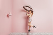 © Marcos Osorio/ADDICTIVE STOCK - Front view of a young girl jumping with an umbrella on pink background