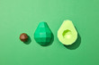 © Yaroslav Danylchenko/Stocksy - Handcraft paper cut avocado and bone presented on a green background with copy space. Healthy fruit. Flat lay