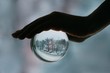 © Liliya Rodnikova/Stocksy - Crop hand holding sphere with winter landscape