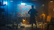 © Gorodenkoff - Talented Female Artist Works on Abstract Oil Painting, with Broad Strokes of Paint Brush She Creates Modern Masterpiece. Dark and Messy Creative Studio where Large Canvas Stands on Easel Illuminated