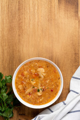 Sticker - Dal - Traditional spicy Indian soup of red lentils and vegetables in a white bowl on a wooden background, top view, copy space. Indian and vegetarian food.