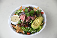 Steak And Avocado Over Salad Served In Bowl