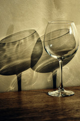 Single glass on the table with double shadows