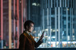 © JIACHUAN LIU/Stocksy - Business man using smart phone at night.