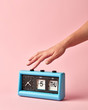 © Yaroslav Danylchenko/Stocksy - Woman's hand turns off the button on retro flip clock with calendar day thuesday, date 5, on a background color of the year 2019 Living Coral .