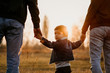 © Olena Bloshchynska - Happy family walking together at sunset in autumn meadow.