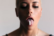 © Lucas Ottone/Stocksy - Woman with a white pill on her tongue