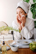 © lordn - Young woman applying face mask at home. Natural Skin Care Routine. Cleaning face with natural cosmetics.