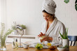 © lordn - Young woman applying face mask at home. Natural Skin Care Routine. Cleaning face with natural cosmetics.