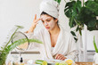 © lordn - Young woman applying face mask at home. Natural Skin Care Routine. Cleaning face with natural cosmetics.