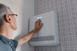 © Milles Studio/Stocksy - Man pushing button on new air conditioner