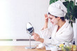 © lordn - Young woman applying face mask at home. Natural Skin Care Routine. Cleaning face with natural cosmetics.