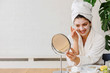 © lordn - Young woman applying face mask at home. Natural Skin Care Routine. Cleaning face with natural cosmetics.
