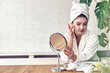 © lordn - Young woman applying face mask at home. Natural Skin Care Routine. Cleaning face with natural cosmetics.