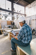 © Raymond Forbes LLC/Stocksy - Worker Using Tablet Computer in Workshop