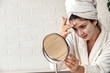 © lordn - Young woman applying face mask at home. Natural Skin Care Routine. Cleaning face with natural cosmetics.