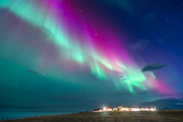 Wall Mural - colorful northern lights on a iceland beach with cottages