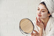 © lordn - Young woman applying face mask at home. Natural Skin Care Routine. Cleaning face with natural cosmetics.