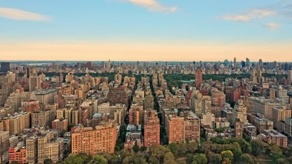 Fototapete - Aerial drone footage of New York midtown skyline at sunset viewed from above upper West Side neighborhood, with slow camera rotation