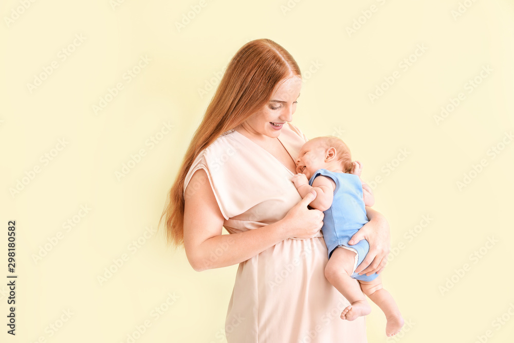 Mother with cute baby on color background