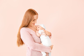 Wall Mural - Mother with cute baby on color background