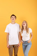 © speed300 - Happy emotional man and woman looking upwards at empty space, orange studio background