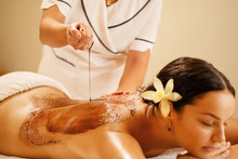 Relaxed Woman Receiving Hot Chocolate Back Massage At The Spa.