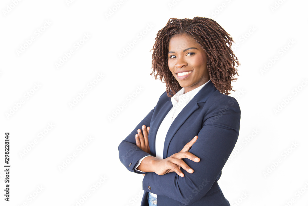 Happy successful female professional smiling at camera. Young African American business woman with arms crossed standing isolated over white background. Confident businesswoman concept - obrazy, fototapety, plakaty 
