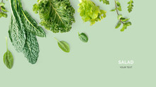 Creative Layout Made Of Kale, Salad Leaves, Spinach, Ruccola On Green Background. Flat Lay. Food Concept. Macro Concept.