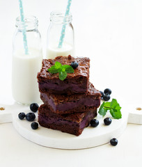 Wall Mural - Chocolate brownies with blueberries and cream filling. Dark background.