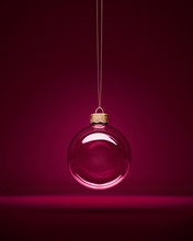Glass Christmas Bauble Hanging In Front Of Luxury Dark Purple Background.