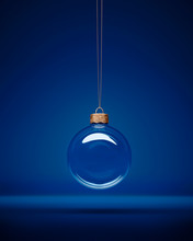 Glass Christmas Bauble Hanging In Front Of Luxury Dark Blue Background.