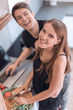 © ASDF - happy young woman standing near the table in her kitchen